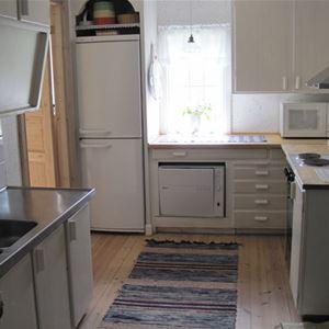 Fullutrustat kök med diskbänk, kyl o frys och  fönster vid köksbänken.