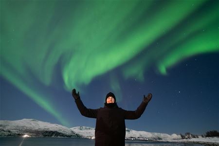En gjest skaper god stemning med nordlyset i bakgrunnen