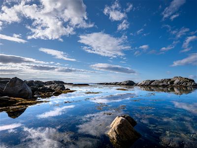 Utsikt over fjorden, steinene og bergene rundt vannet