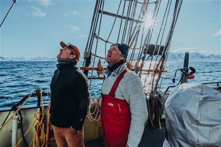 Two people looking at a sail