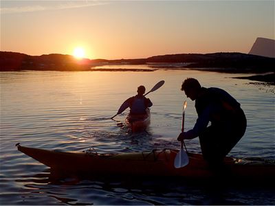 Two people starting to paddle out on kayaks