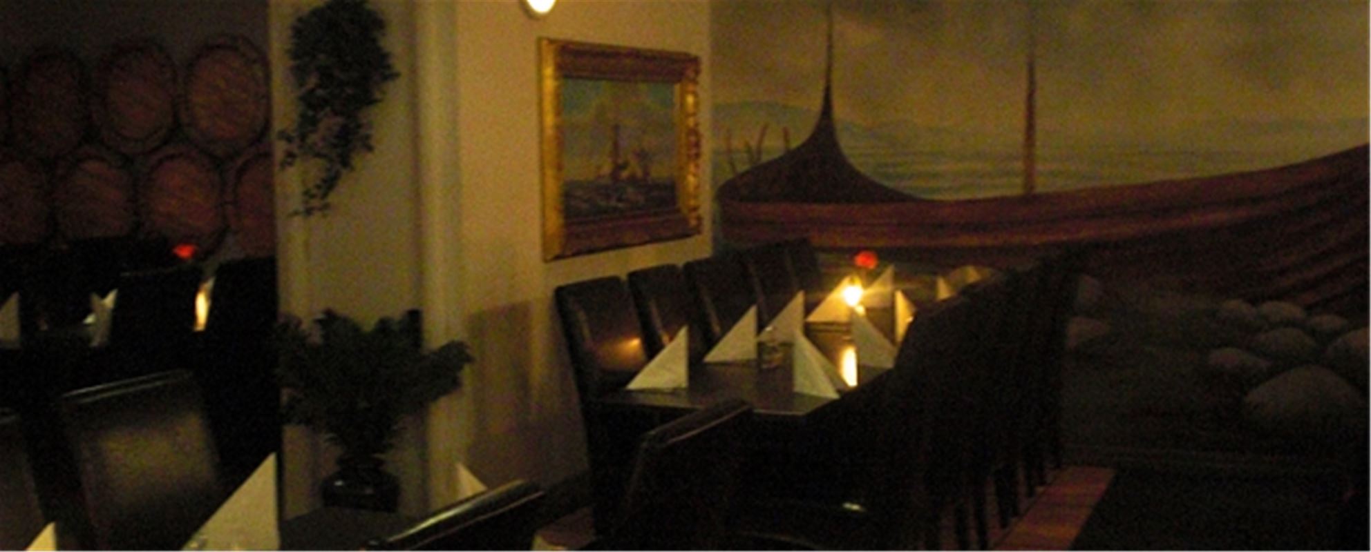 Interior picture from the restaurant, a set table with lit candles on the table.
