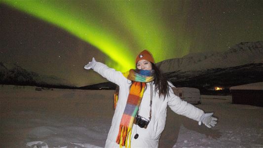 A guest standing under the Northern Lights