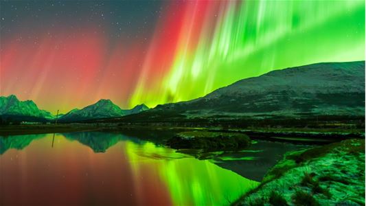 Northern Lights above snow covered mountains