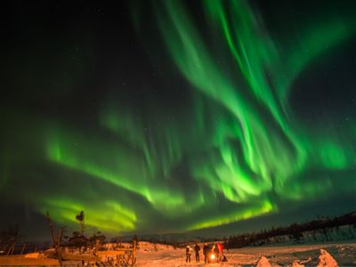 Gjester rundt et bål under nordlyset