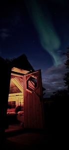 Åpen hytte med nordlys