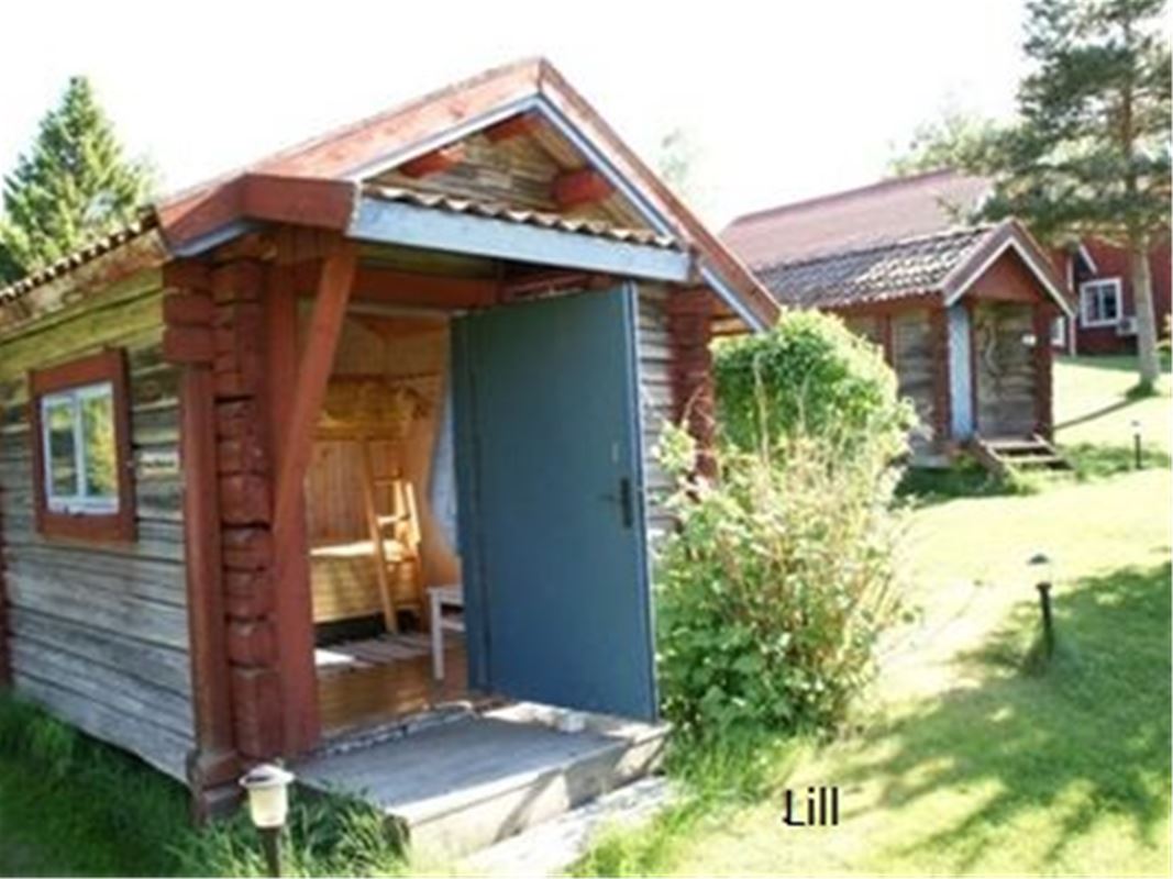 Cabin Lill is a small timber cottage with a blue door. 