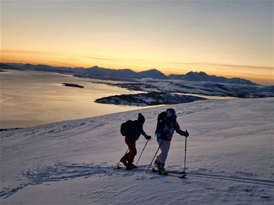 To gjester følger skisporene, men fjorden reflekterer ettermiddagslyset