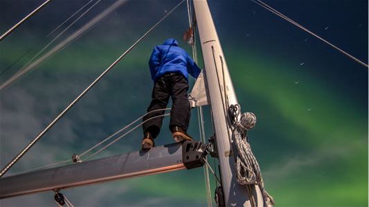 En person på seilbåten som ser på nordlyset