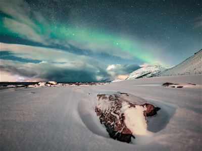 Nordlys og snødekt landskap