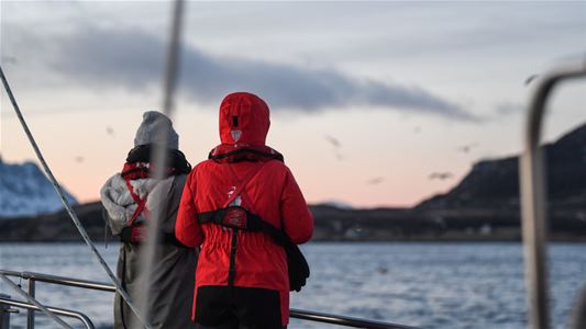To gjester som nyter utsikten fra en seilbåt