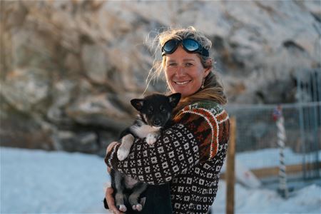 A person holding a husky puppy