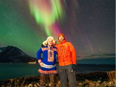 Tour leader and guest pose in front of the Aurora