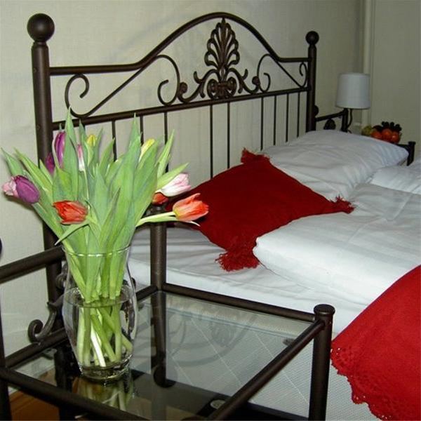 Double bed with tulips on the bedside table. 