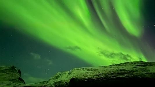 Northern lights over snowcovered mountains