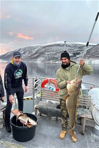 En gjest viser sin fiskefangst