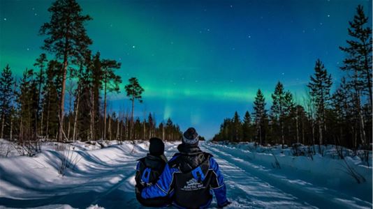 Two guests looking at the northern lights