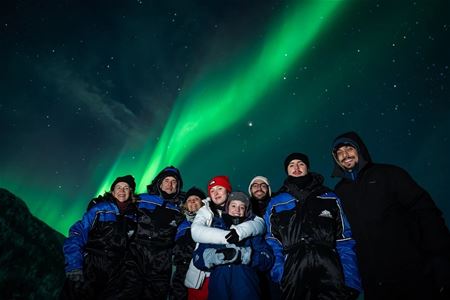 Group of guests and the northern lights