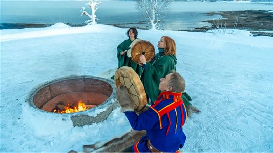 Sámi shaman with two guests playing drums