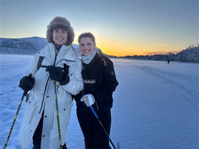 Two smiling guests with a nice sky in the background