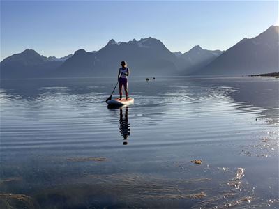 Gjest står på et SUP-brett