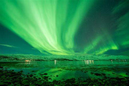 Nordlyset flyr over fjorden