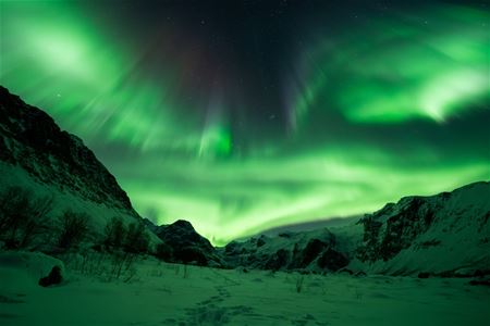 Nordlyset skinner ut siden av et fjell