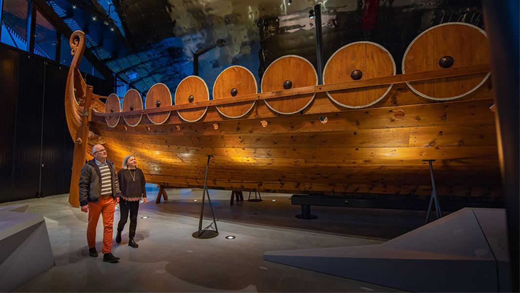 Visitors observing the impressive Myklebust Ship inside Sagastad Viking Center.