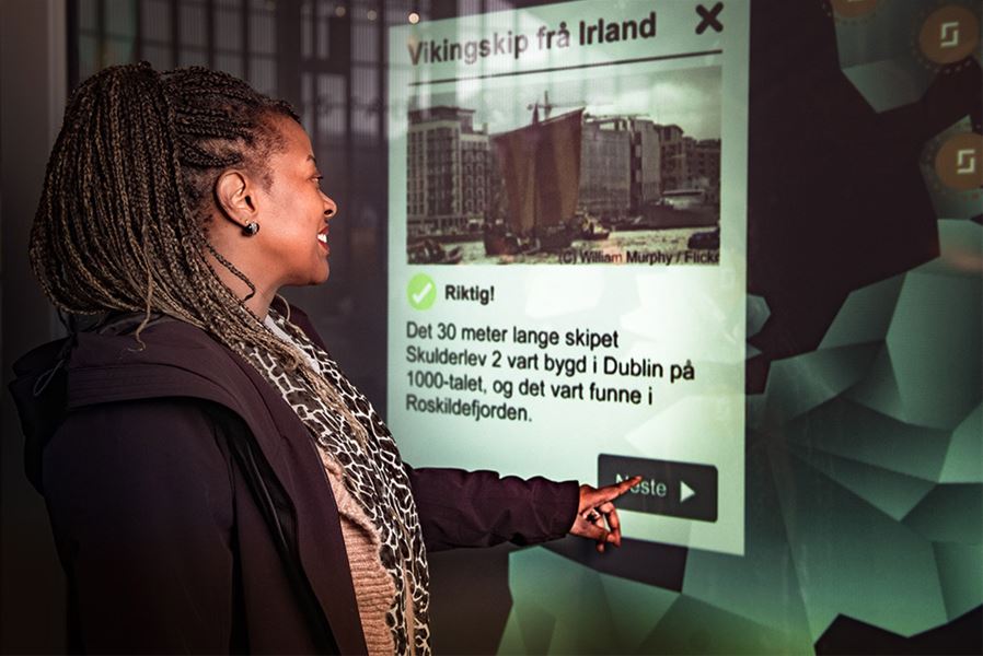 A visitor using an information screen to learn more about the Viking Age.