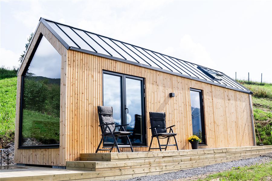 Nilsstova omgitt av frukttre på Påldtun – ein roleg og naturnær stad å bu.