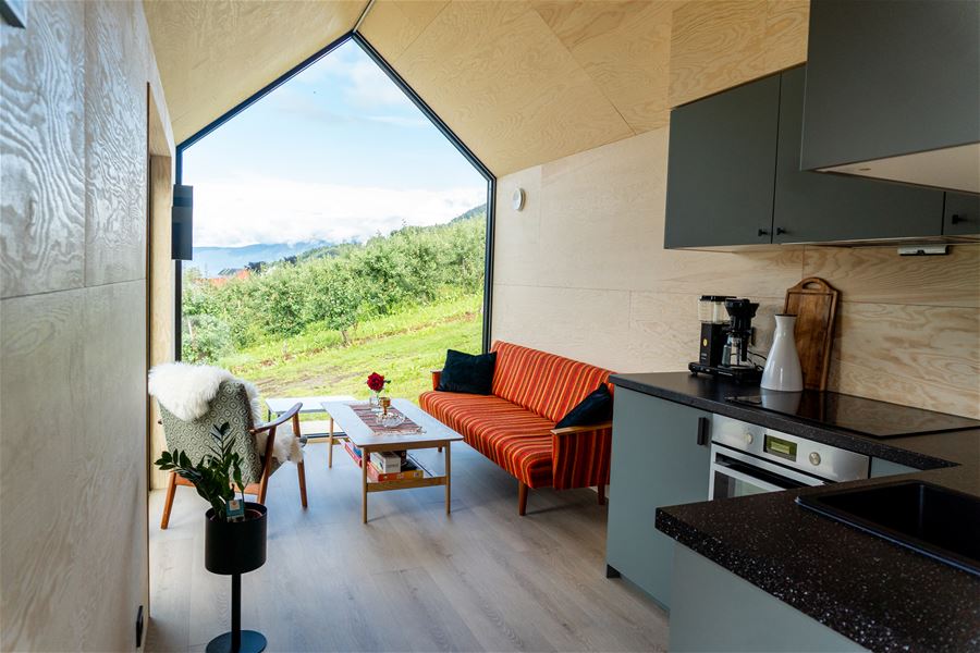 Open løysing med kjøkken og stove i den sjarmerande hytta Nilsstova.