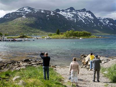 Gjester tar bilder av fjell og kystlandskap