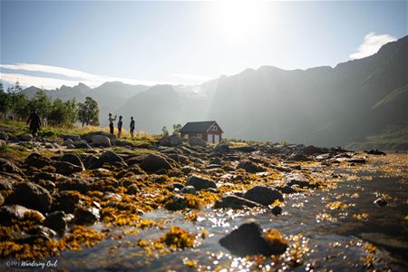 Some people by a building near the shore