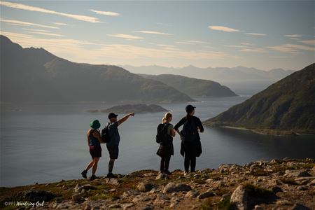 A group of people hiking with mountains and the sea in the background