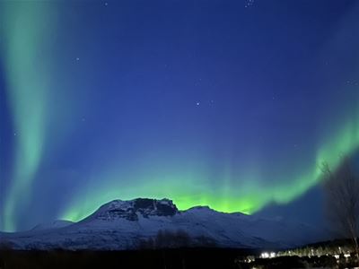 Aurora former en ujevn linje bak fjellet