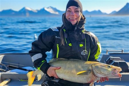 A person holding a fish on a boat