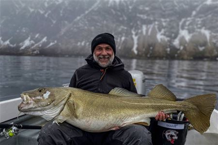 A person holding a fish on a boat