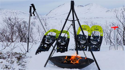 Snowshoes by a campfire