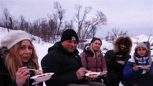 A group eating around a campfire