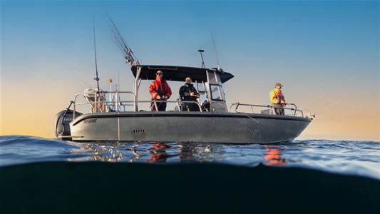Flere personer som fisker fra en båt