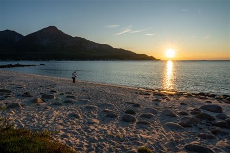 Strand med fjell i bakgrunnen
