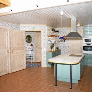 Spacious kitchen with green cabinet doors. 
