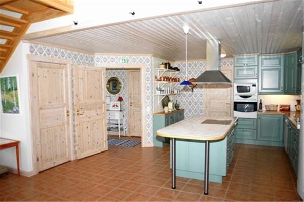Spacious kitchen with green cabinet doors.  