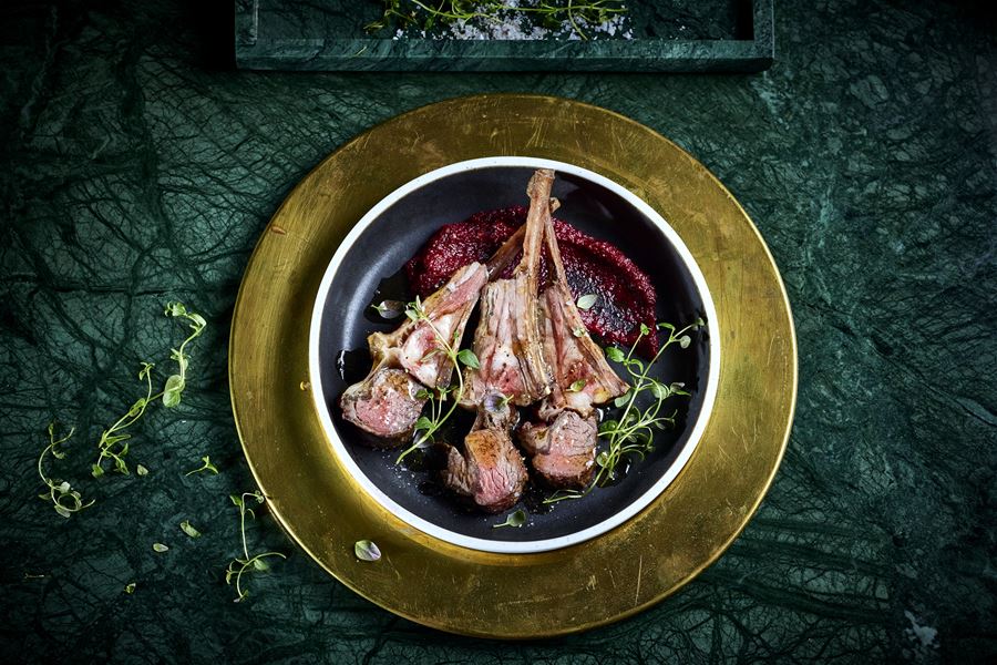 Tallerken med lammecarre toppa med urter og servert med raud saus på Sølvene Gard Restaurant..