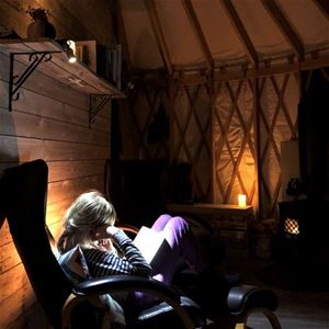 Leser bok inne i hytta