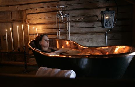 Tjej som badar i badkar.