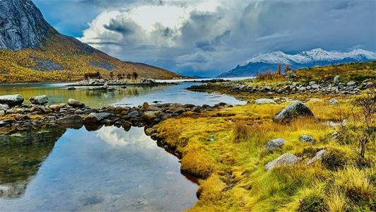 A lake with mountains in the background