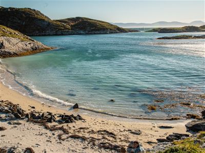 A white sandy beach with crystal-clear blue water in the sunshine