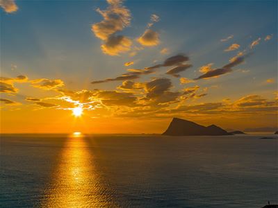 Sunset over the sea with mountains in the background