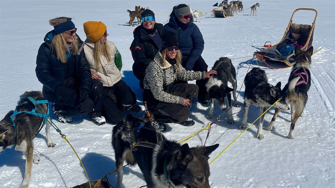 Hundespann med deltakere samlet på snødekt vidde.